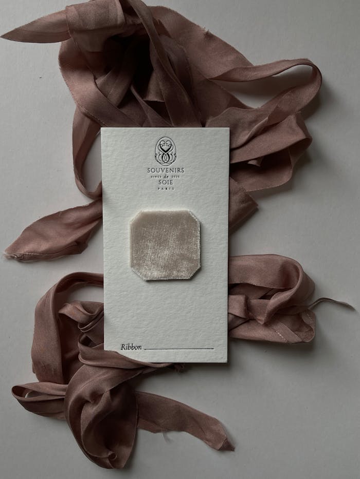 services-04 Flat lay of vintage souvenir card and pink silk ribbon for elegant gifts.