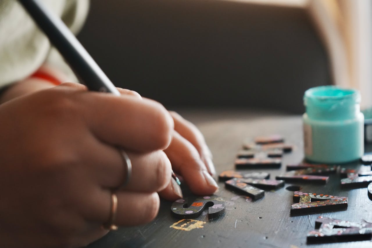 why-choose-us Hands painting wooden letters with precision, showcasing a creative DIY project.