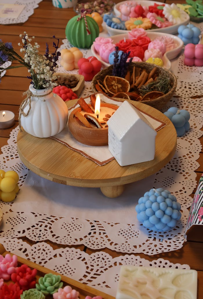 gallery-5 Bright display of handmade candles and decorations on a wooden table.