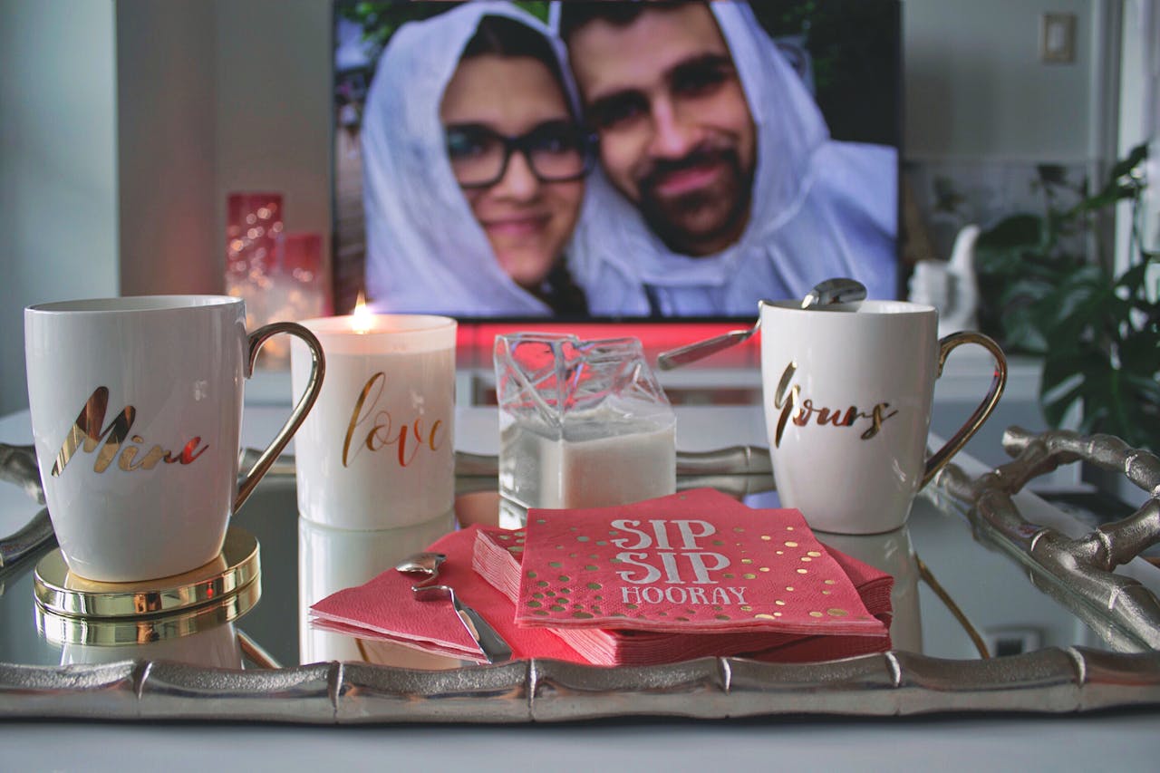 gallery-2 Cozy setting with personalized mugs, candle, and couple's photo, perfect for a romantic coffee date.